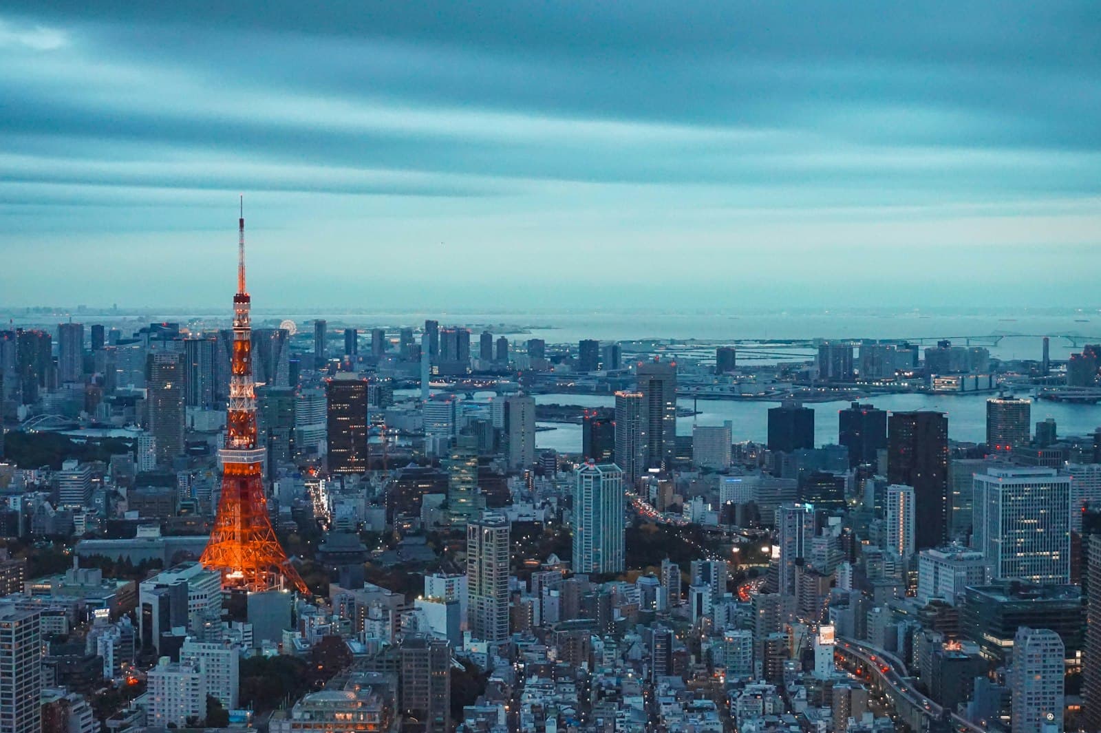 Tokyo Tower illuminated at night — visible from Azabudai Hills rooftops